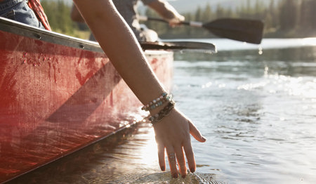 Mehrere Persnen auf einem Kanu. Eine Frau hält ihre Hand ins Wasser.